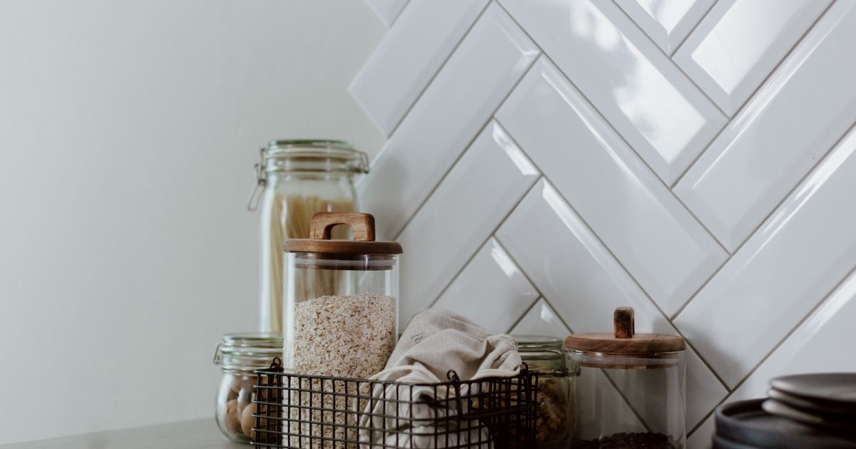 Glass jars with airtight lids on a kitchen shelf, used for storing salt and dry goods